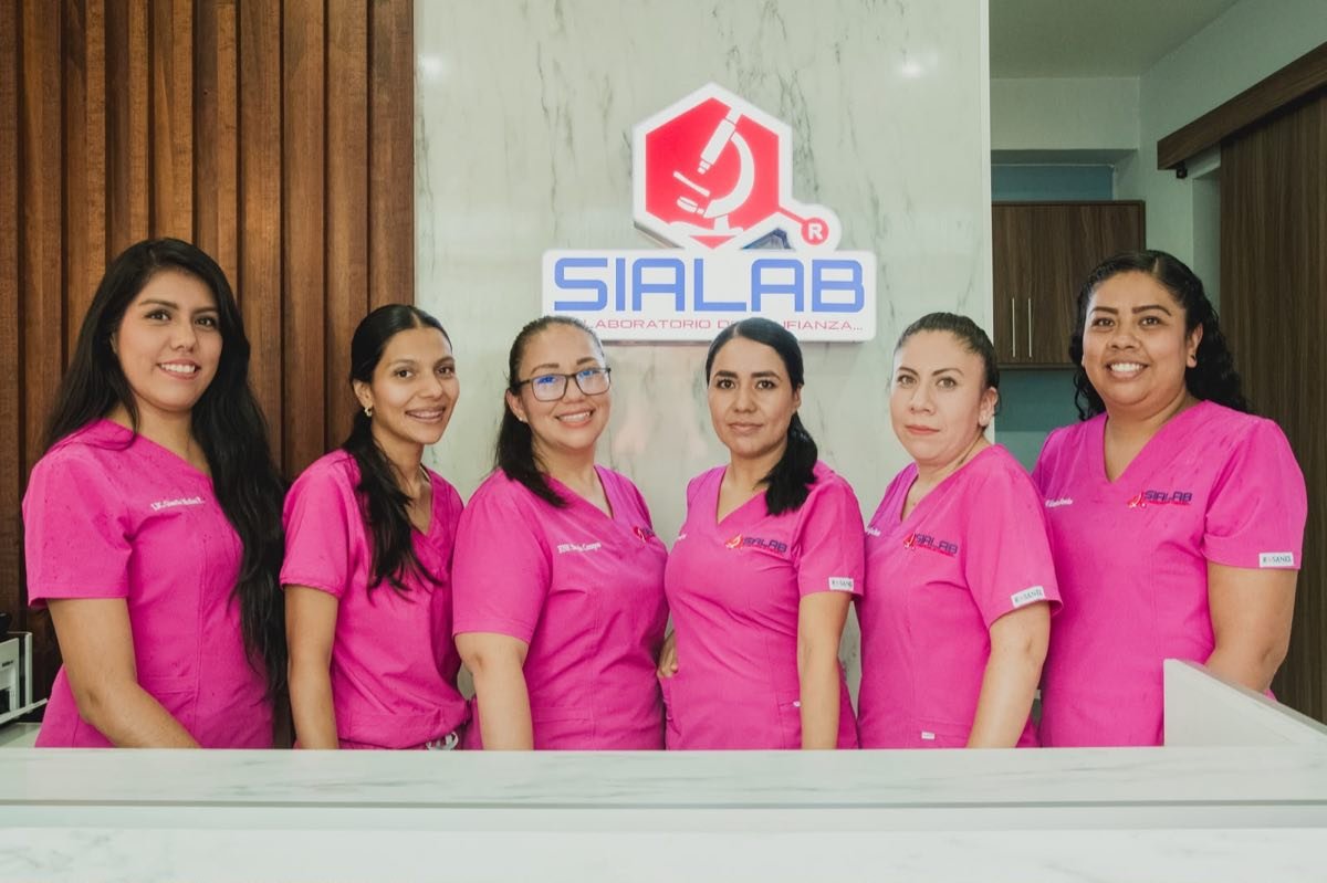 Personal joven de SIALAB sonriendo en la recepción