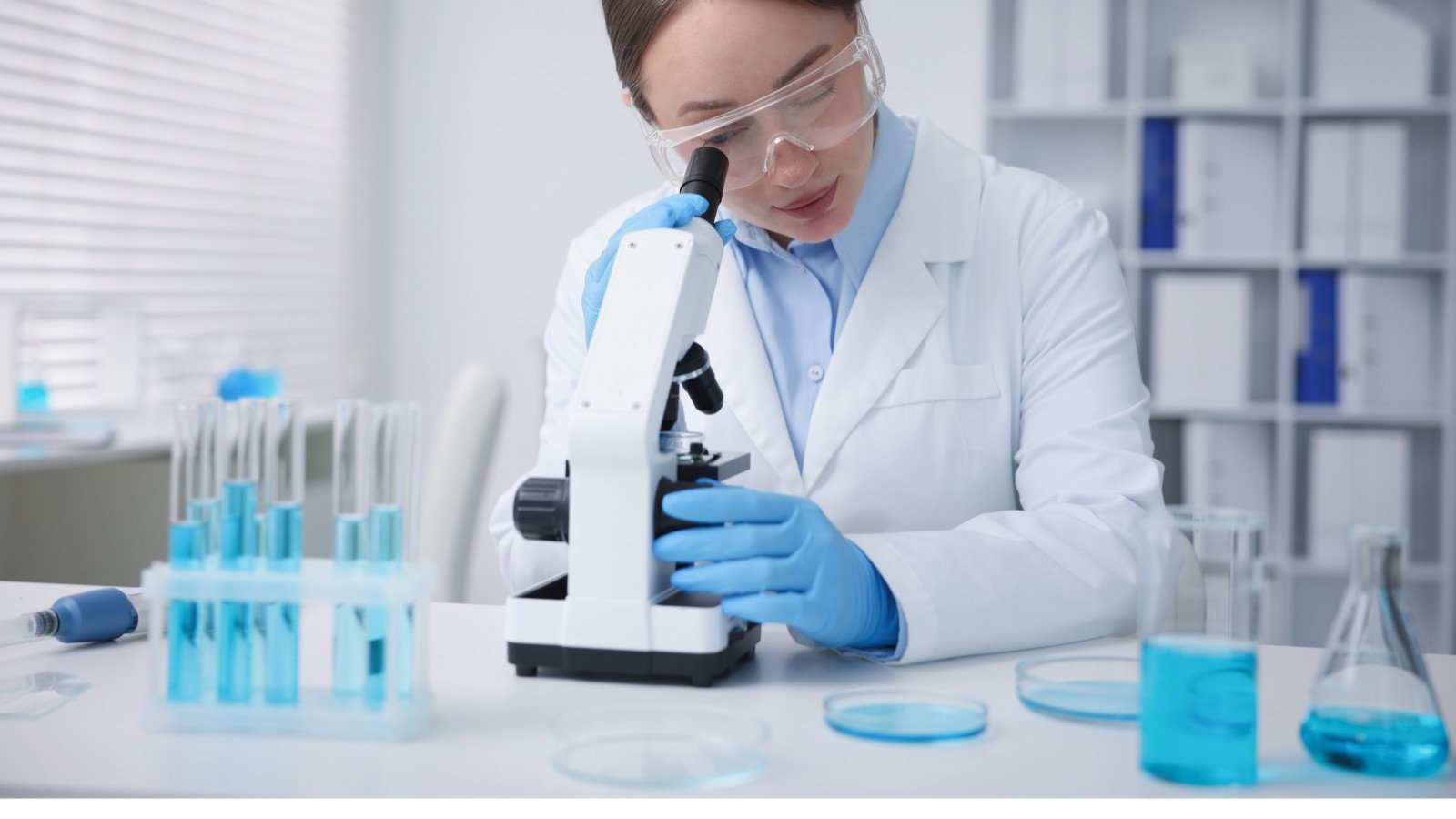 Técnica de laboratorio analizando una muestra con microscopio digital